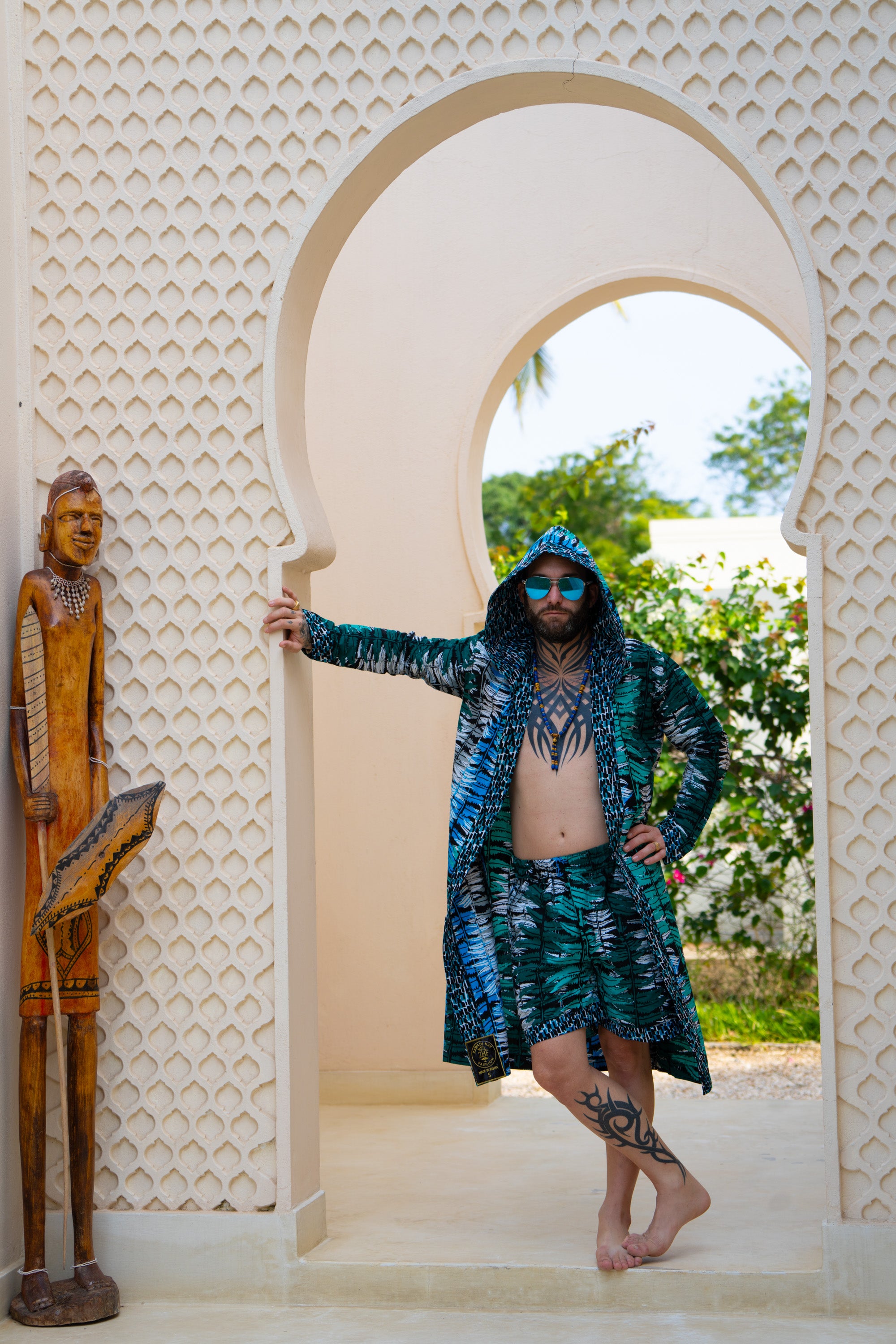 Man wearing Ocean Teal African cover-up and shorts set in teal-inspired African print.
