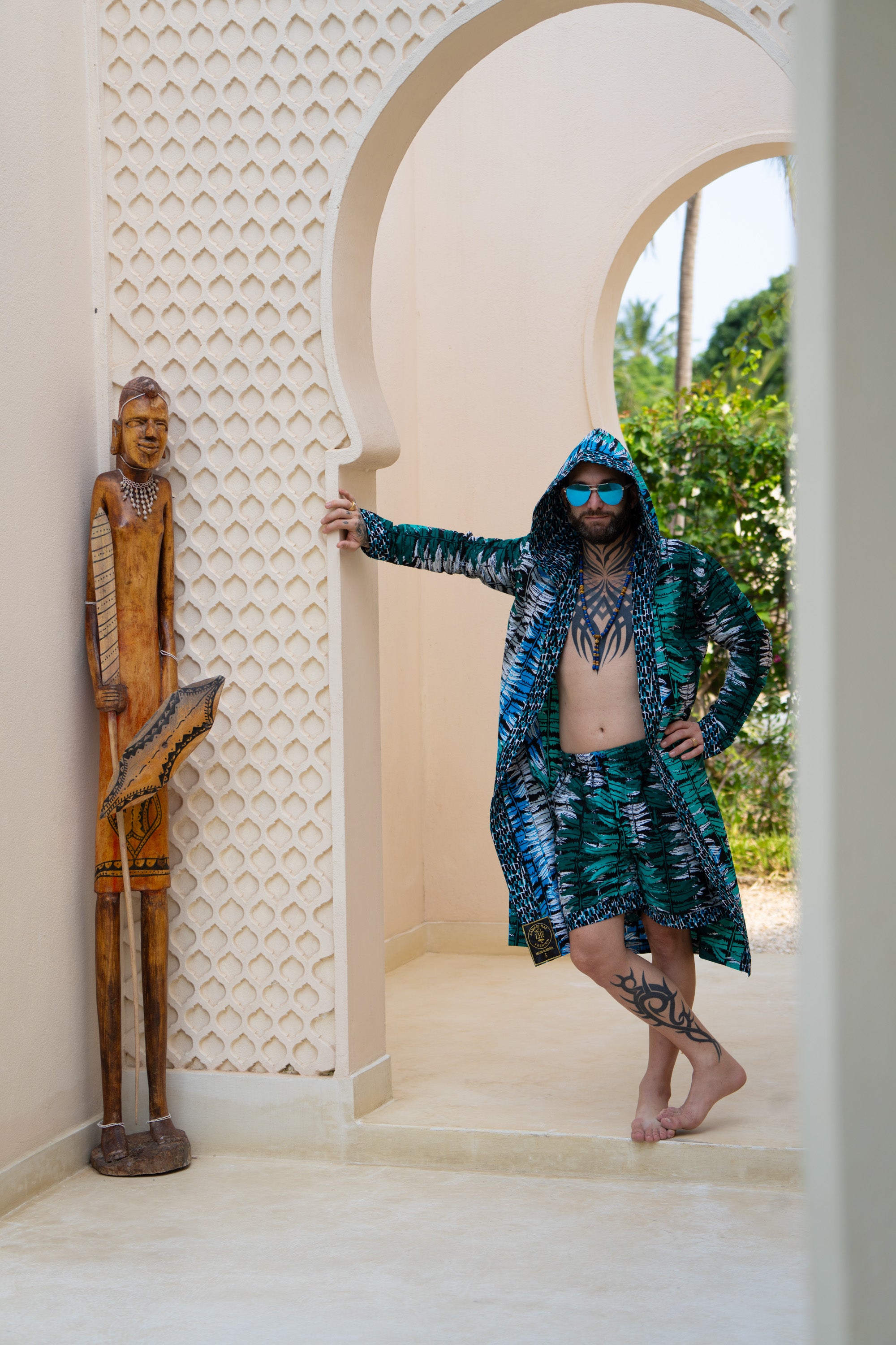 Man wearing Ocean Teal African cover-up and shorts set in teal-inspired African print.