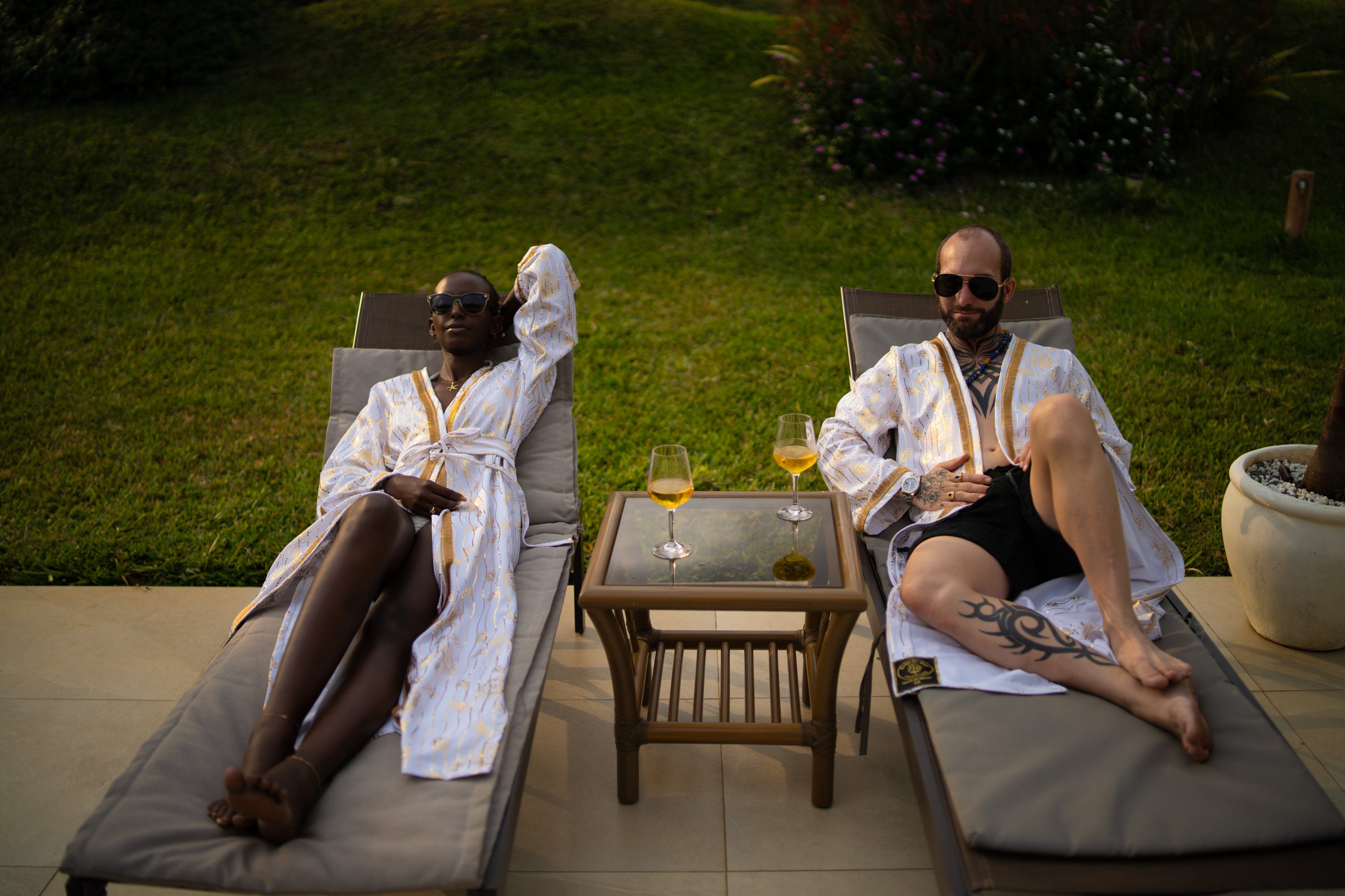 A couple wearing White and Gold cover-up with golden accents.