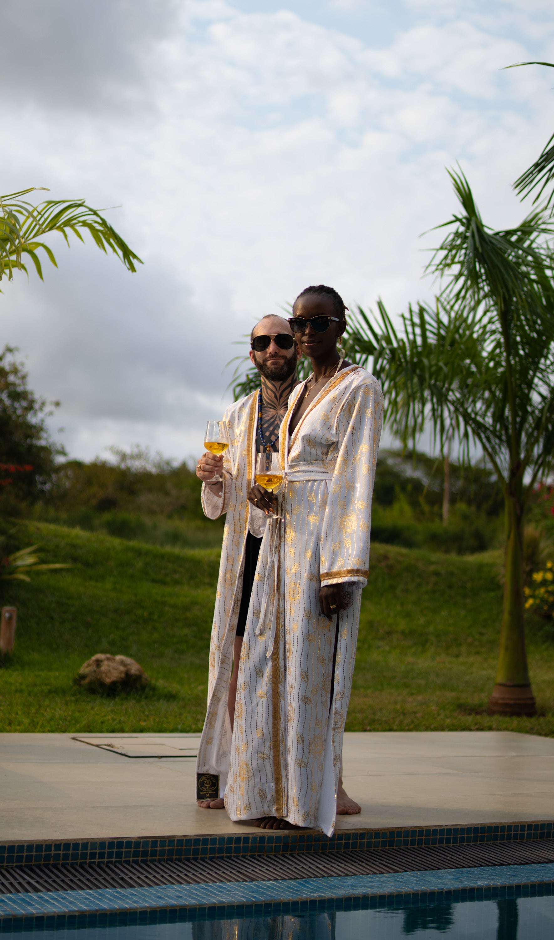 A couple wearing White and Gold cover-up with golden accents